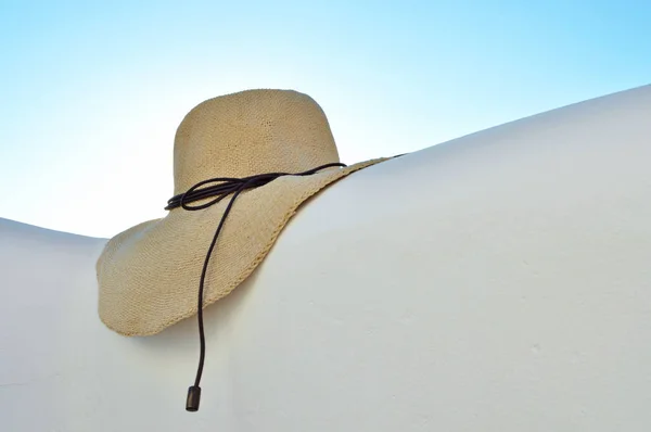 Straw hat on white wall and sky background