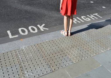 Londra 'da tipik bir trafik işaretinin yanında duran yayalar.