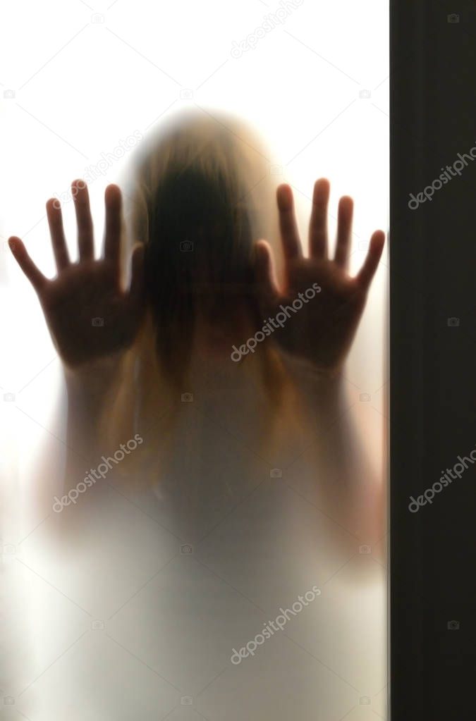 Girl silhouette behind frosted glass