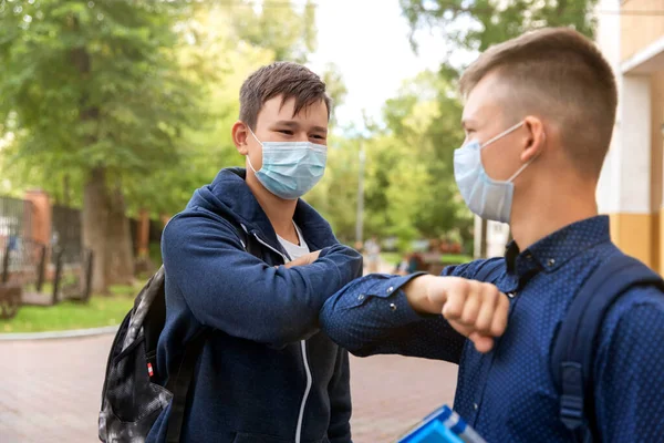 Two school friends greet each other in the schoolyard. — Stock Photo, Image