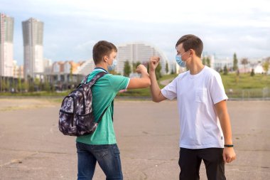 Gençlerin iki arkadaşı şehirde buluşuyor. Birbirlerine dokunmadan selamlaşıyorlar. .