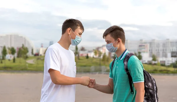 Two friends of teenagers meet in the city. They greet each other without contact . — Stock Photo, Image