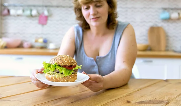 Eine Junge Frau Hält Einen Burger Der Hand Sie Sitzt — Stockfoto