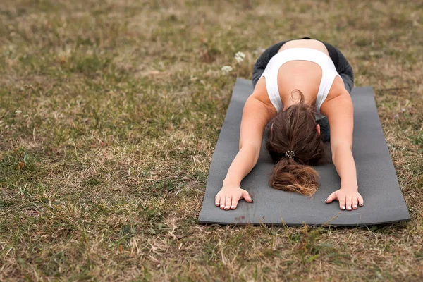 Young sporty woman doing fitness exercises near the river against the background of the forest. Young sporty woman doing fitness exercises near the river against the background of the forest.