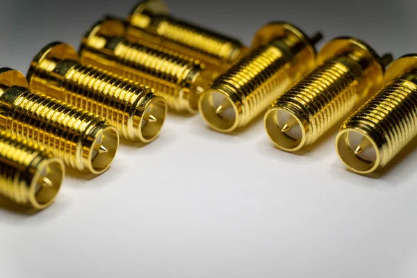 Close-up of symmetric aligned gold plated SMA male connectors electronics components in partial focus white background — Stock Photo, Image