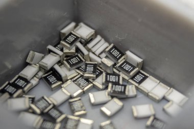 Gri dağınık mikroskobik SMT yüzey montaj çipi rezistörleri gri depolama konteynırında sıralandı