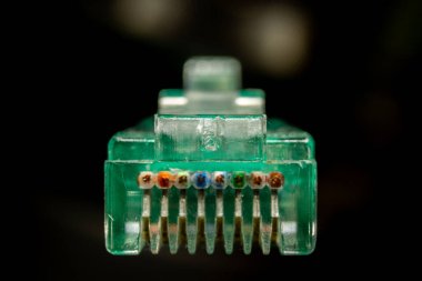 Yeşil RJ45 CAT6 kalkanlı ağ veri kablosu koyu arkaplan üzerinde açık bağlantı makro kesit ön açı görünümü
