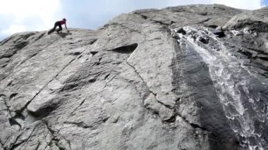 Şelaleyle kayaya tırmanan adamın alt görüntüsü