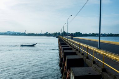 Kolombiya, Tumaco Limanı 'ndaki köprüden geçen sürat teknesindeki adam.
