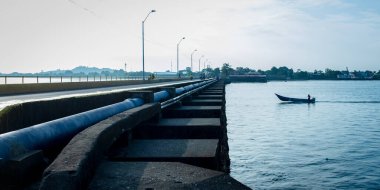 Kolombiya, Tumaco Limanı 'ndaki köprüden geçen sürat teknesindeki adam.