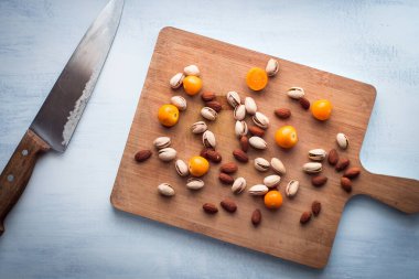 Badem, Pistachios ve Gooseberry Burnu Kesme tahtasında Bıçağın yanında