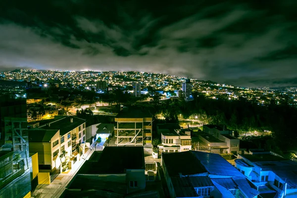 La ciudad vista desde lo alto del edificio por la noche con un cielo dramático / paisaje nocturno en la Cordillera de los Andes Real — Foto de Stock