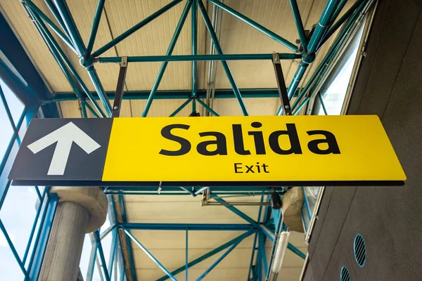 Sinal de saída escrito em espanhol e inglês na estação — Fotografia de Stock