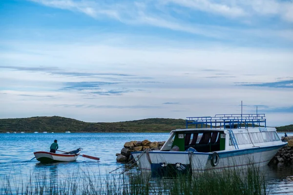 Joven Aymara remando en un pequeño barco en la bahía de Challa ubicada en la isla del Sol ) — Foto de Stock