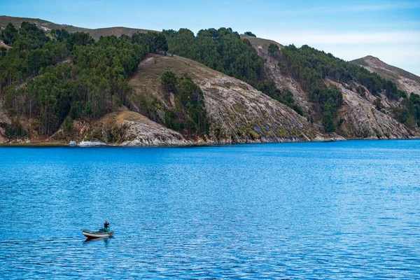 Aymara Man remando y pescando en un pequeño barco en la pintoresca bahía de Challa situada en la famosa isla del sol (Isla del Sol ) — Foto de Stock