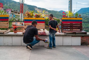 Medellin, Antioquia / Kolombiya - 11 Ağustos 2019: 13. Komün 'de babasıyla birlikte Kolombiya Bayrağının Renklerini Boyayan Küçük Çocuk