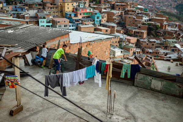 Medellín, Antioquia / Colômbia; 24 de fevereiro de 2019: Criança de bicicleta assistindo no terraço de uma casa em Comuna 13 — Fotografia de Stock