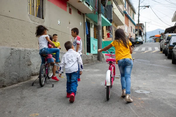 Medellin, Antioquia / Kolombiya - 24 Şubat 2019: Commue 13, Turistik Sanatsal Cazibe Tarihi Mahallesi 'nde Birbirleriyle Konuşan ve Bisikletle Oynayan Çocuklar Grubu — Stok fotoğraf