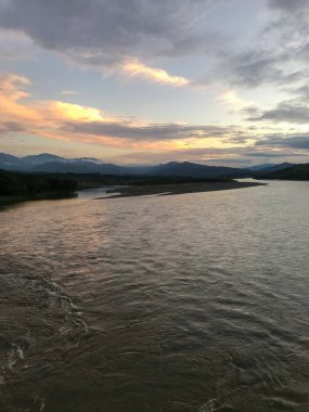 Uzak Mavi Dağlar ve Cauca Nehri üzerinde Pembe Bulutlar manzaralı gün batımı