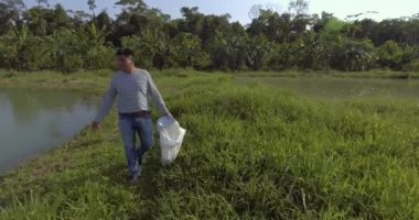 Yapacani, Santa Cruz / Bolivya - 3 Eylül 2017: Balıkçı Balık Göletleri 'ne Tambaqui ve Pacu Balıkları için Dengeli Yiyecek (Serrasalmus) attı