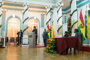 La Paz / Bolivya - 12 Aralık 2016: Yılbaşı süsleri ve Bolivya Bayrakları olan bir odada Halka Birkaç Teşekkür Sözcüğü Söyleyen Yerli Adam