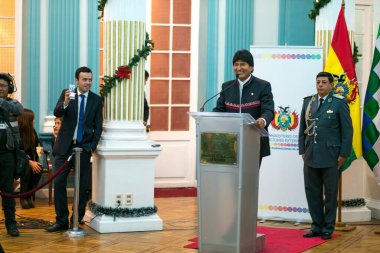 La Paz / Bolivya - 12 Aralık 2016: Yılbaşı süsleri ve Bolivya Bayrakları olan bir odada Halka Birkaç Teşekkür Sözcüğü Söyleyen Yerli Adam