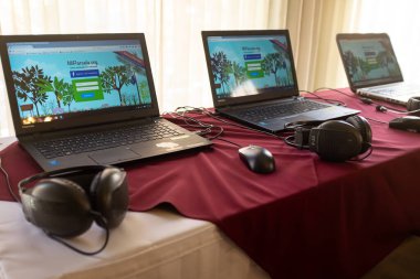 La Paz / Bolivya - 21 Mart 2016: Beyaz ve koyu kırmızı bir masa üzerinde ekranlı dizüstü bilgisayarlar ve kulaklıklar