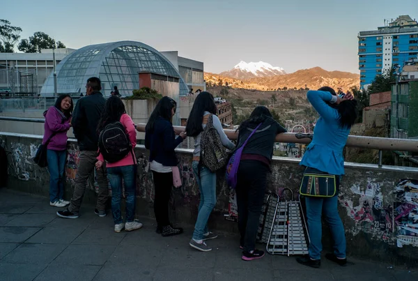 La Paz / Bolivya - 9 Temmuz 2015: Yerli Kadın ve Erkekler Arkaplanda Illimani Karlı Dağ ile Bir Bara Bakıyor