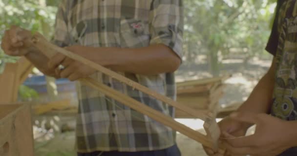 Dwóch Młodych Brązowych Mężczyzn Montuje Drewniany Panel Grubymi Nitkami — Wideo stockowe
