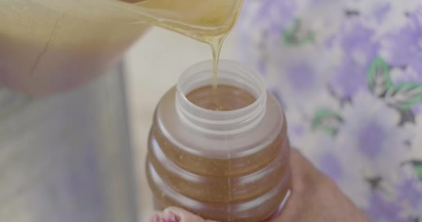 プラスチック製の瓶に入れられた蜂蜜でいっぱいのプラスチック製のジャグ — ストック動画