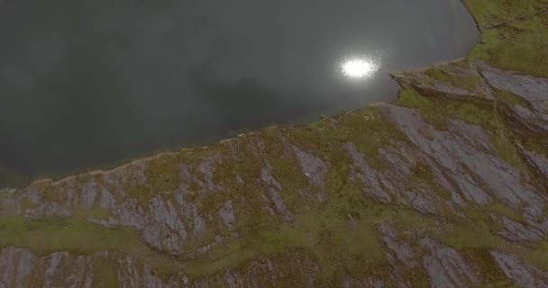 Une lagune sombre par le reflet de la journée entourée de collines vertes et cachée dans le brouillard à Sorata, La Paz, Bolivie