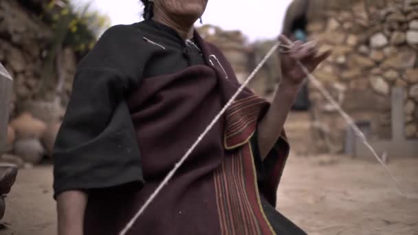アンゴラ チュキサカ ボリビア2014年11月2日 スピンドルとマニュアルホイールを使用した先住民族の特徴と伝統的な服を持つ茶色の女性 — ストック動画