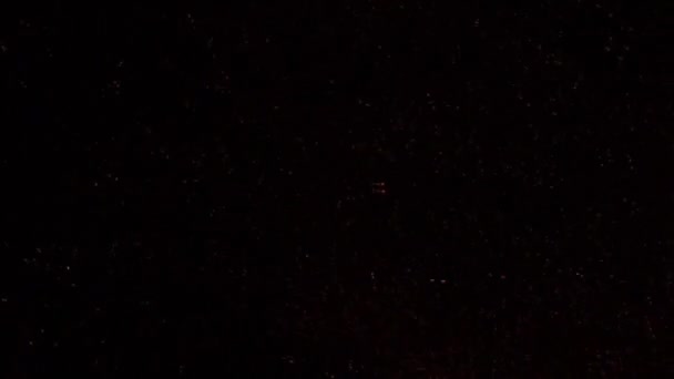 Étincelles dans le feu de camp au coucher du soleil dans la zone de camping dans l'île d'Anticosti, Québec, Canada. 