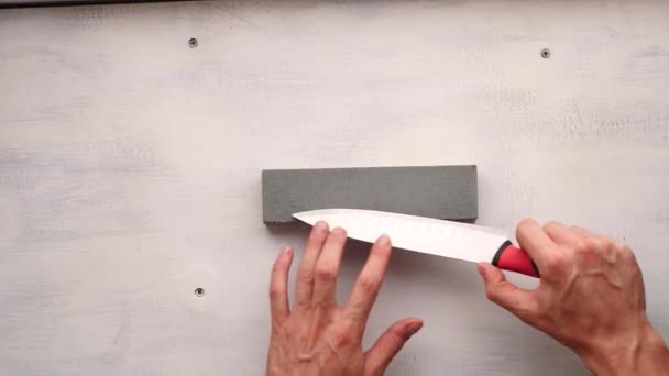 Die Hand Des Weißen Mannes Schärft Ein Küchenmesser Auf Einem — Stockvideo