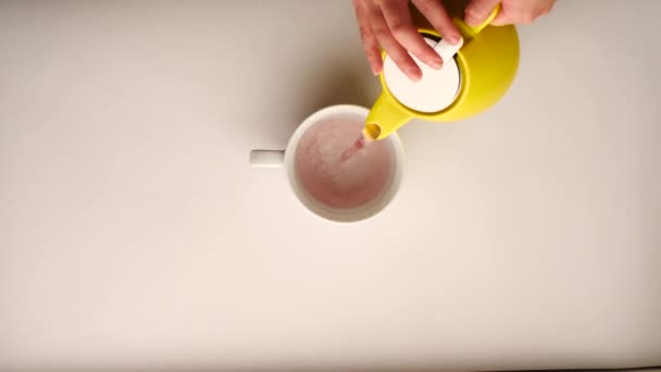 Frauenhände Halten Eine Gelbe Teekanne Der Hand Und Gießen Einen — Stockvideo