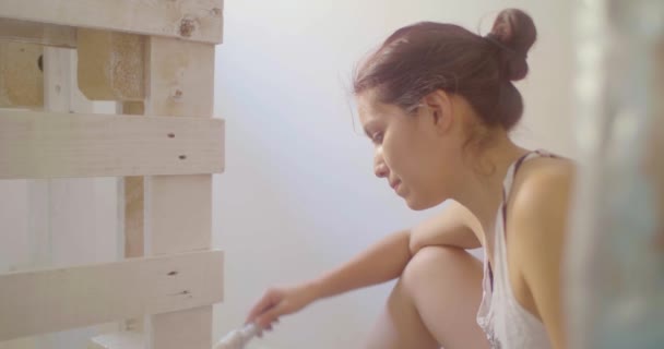 Uma Jovem Latina Está Pintando Uma Peça Mobiliário Feita Pedaços — Vídeo de Stock