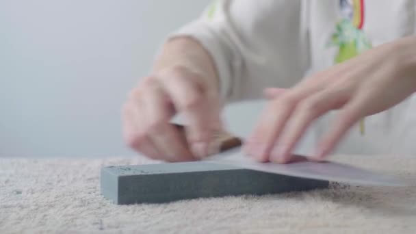 Рука Белого Человека Затачивает Кухонный Нож Прямоугольном Камне Белом Фоне — стоковое видео