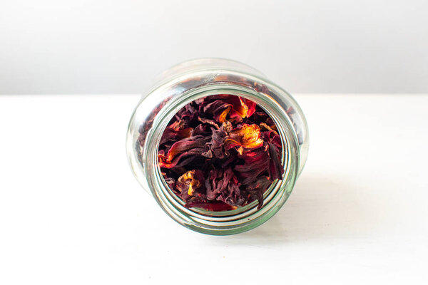 White Wooden Table with Hibiscus Flower / Roselle (Hibiscus sabdariffa)  in a Jar