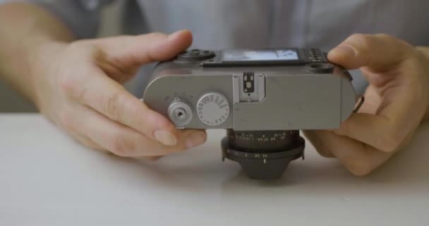Καυκάσιος Βλέπει Την Παλιά Κάμερα Ένα Λευκό Τραπέζι — Αρχείο Βίντεο