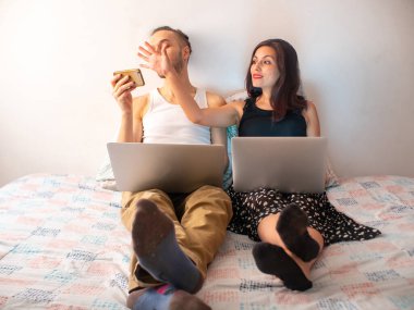 Kıskanç Latin Kadın, beyaz erkek arkadaşının laptoplarla yataktayken telefonunu görmesine izin vermiyor.