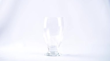 Buz küpleri, Beyaz Arkaplanda Temiz Cam Kupa 'ya atılır.