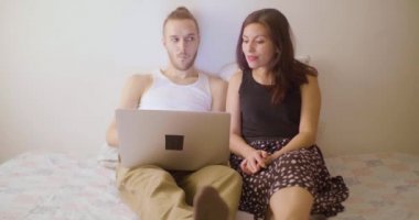 İspanyol bir kadın ve Kafkas Sarışın bir adam dizüstü bilgisayardan aileleriyle birlikte el sallıyorlar ve kötü bir internet bağlantıları var çünkü birbirlerini duyamıyorlar.