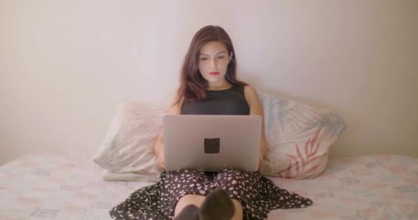 Испанская Женщина Пишет Письмо Ноутбуке Компьютера Сидя Постели — стоковое видео