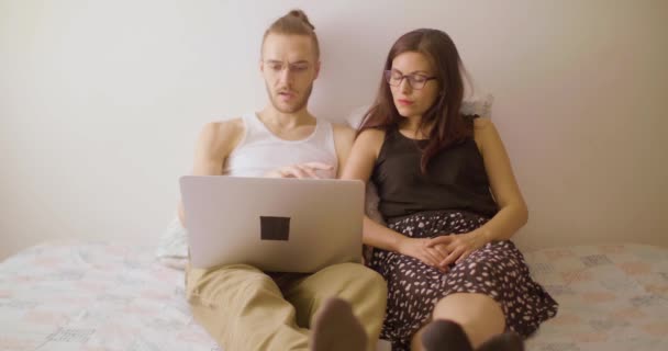 一个白种人向一个戴眼镜的西班牙女人解释笔记本电脑上的电影 — 图库视频影像