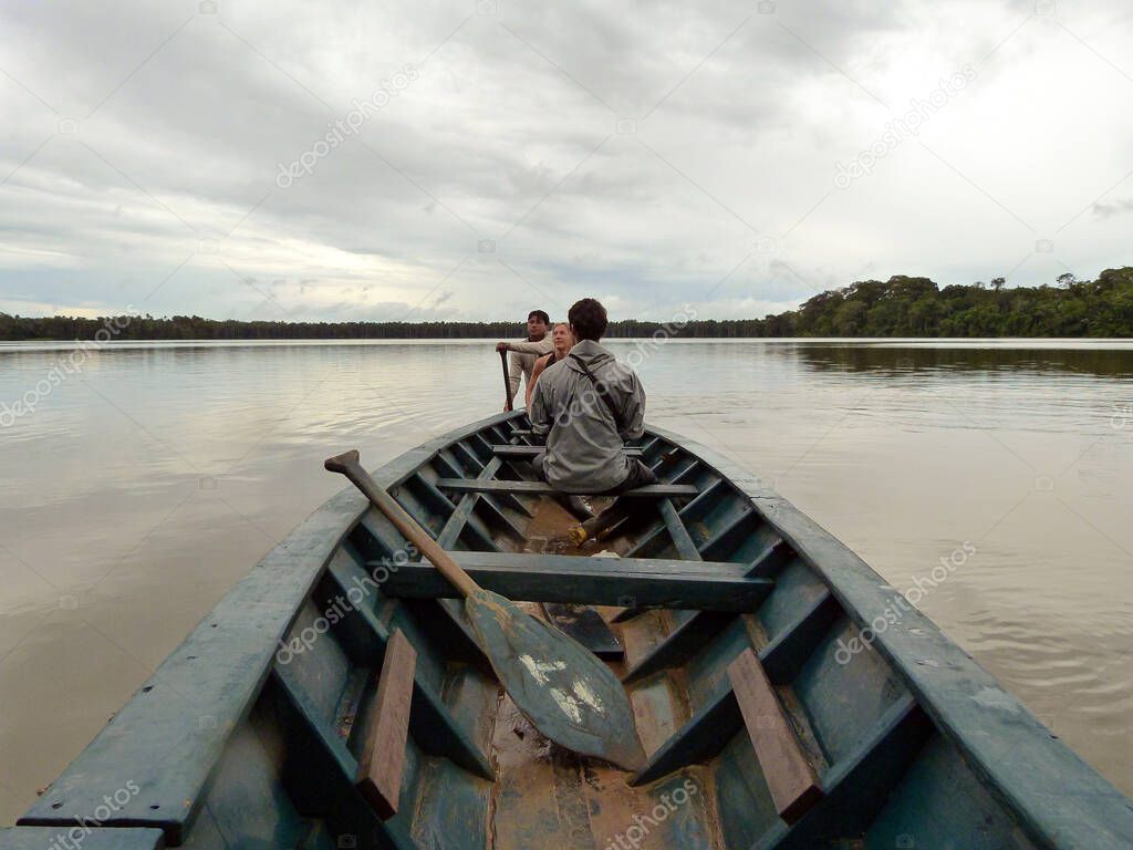 Puerto Maldonado, Madre de Dios / Peru - February 3 2013: Man Rowing a Canoe with other People in the Madre de Dios River in the Peruvian Amazon