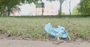 Mavi Covid-19 Önleme Maskesi Kirli ve Çöpe atılmış Bir Kişi tarafından toplandı 
