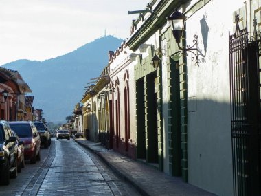 San Cristobal de las Casas, Chiapas / Mexico - 8 Ocak 2012: Yolcular Sarı ve Kırmızı İkonik Katedralinden Geçiyor