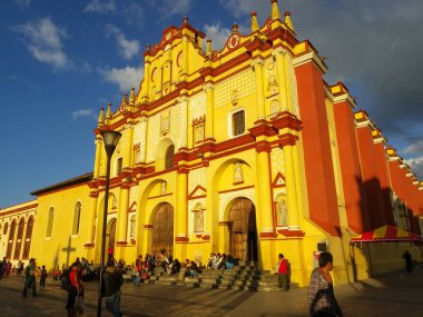 San Cristobal de las Casas, Chiapas / Mexico - 8 Ocak 2012: Yolcular Sarı ve Kırmızı İkonik Katedralinden Geçiyor