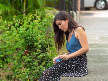 İspanyol Genç Kadın Kaldırımda Oturuyor Mavi Çiçek Maskesini Tutuyor