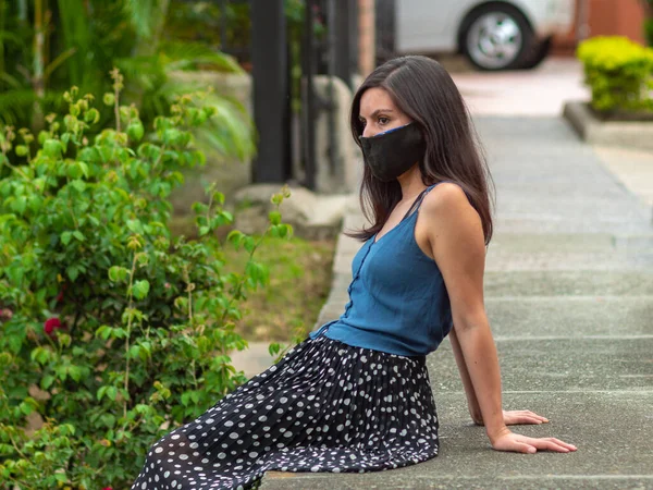 Junge Frau Sitzt Mit Dunkler Maske Auf Dem Bürgersteig Und — Stockfoto